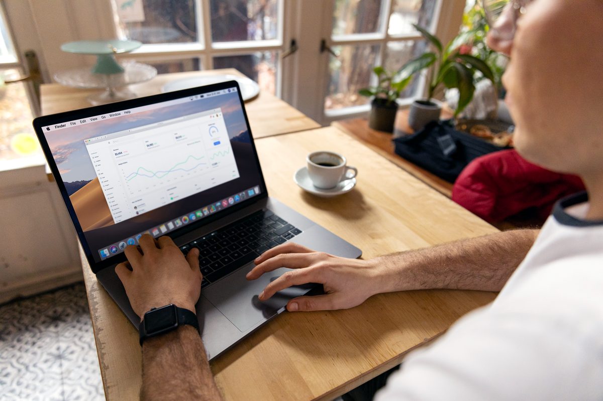 Empresario revisando el informe de tráfico de su web en el portátil
