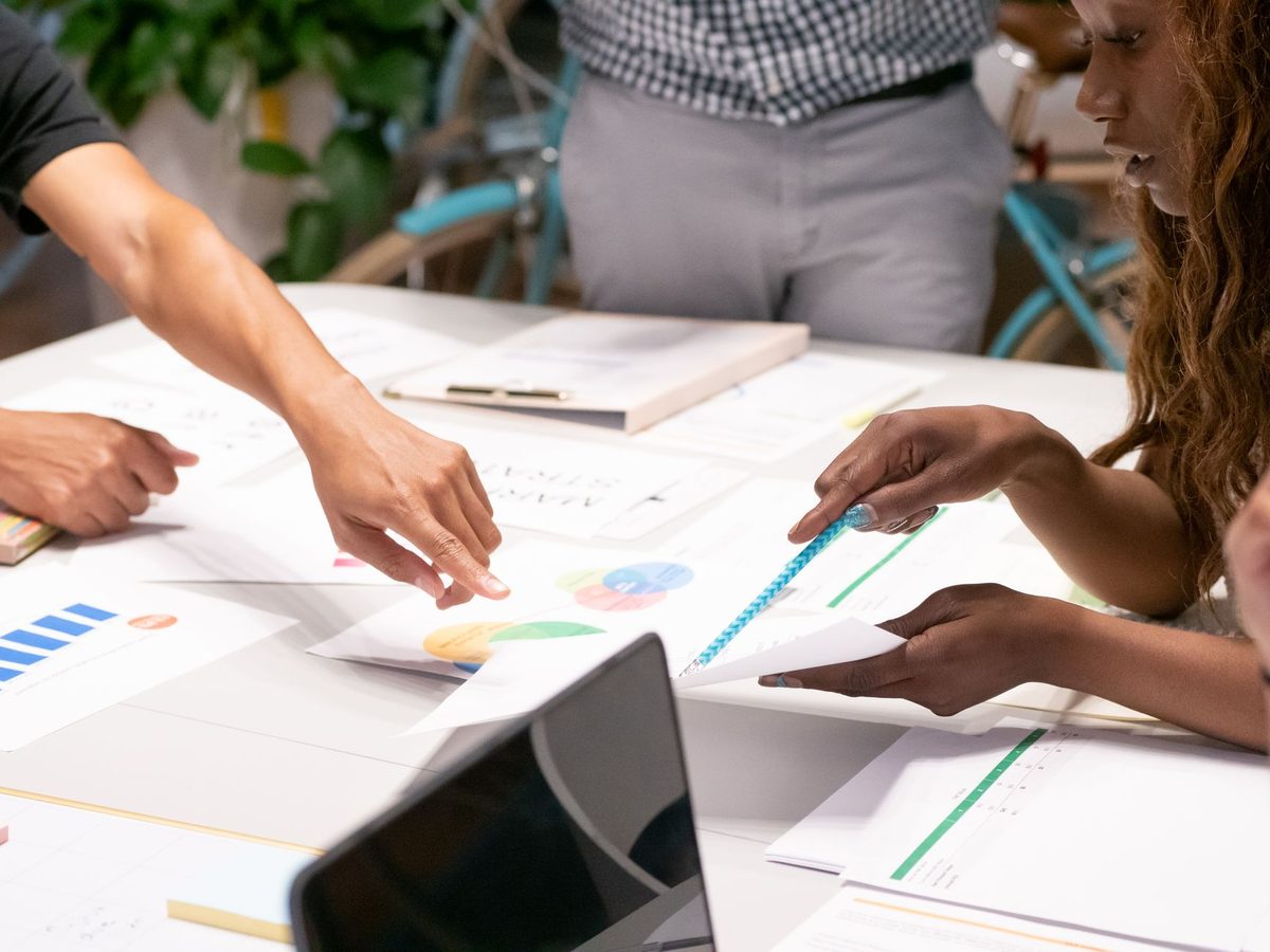 Equipo de una pequena empresa planificando una campana de publicidad digital en una mesa de trabajo