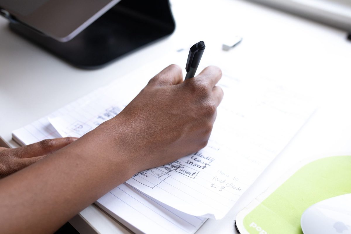Una persona del equipo anota en un cuaderno el registro interno de formación en inteligencia artificial