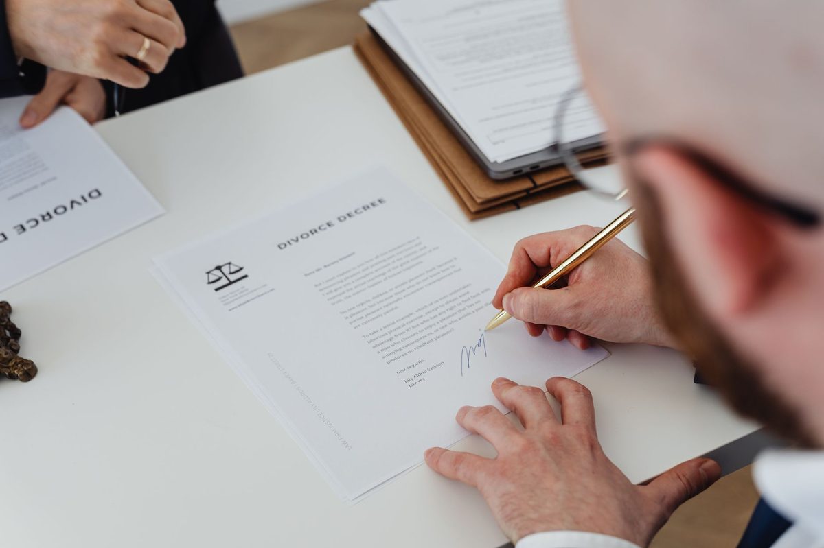 Persona corrigiendo a mano un documento de trabajo sobre el escritorio de la oficina