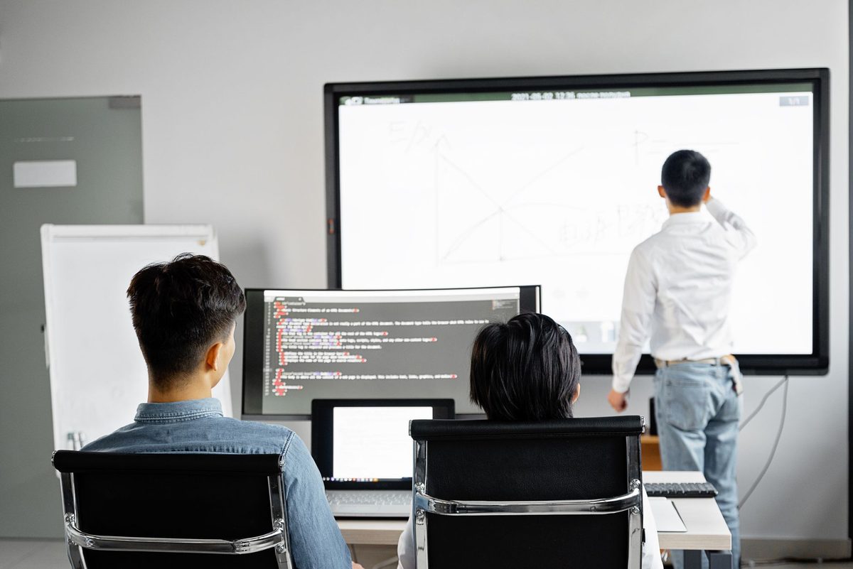 Equipo de oficina revisando en varias pantallas el estado de un proceso conectado de principio a fin