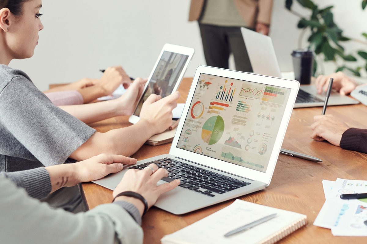 Empleados comparando herramientas de automatización en un portátil durante una reunión de trabajo