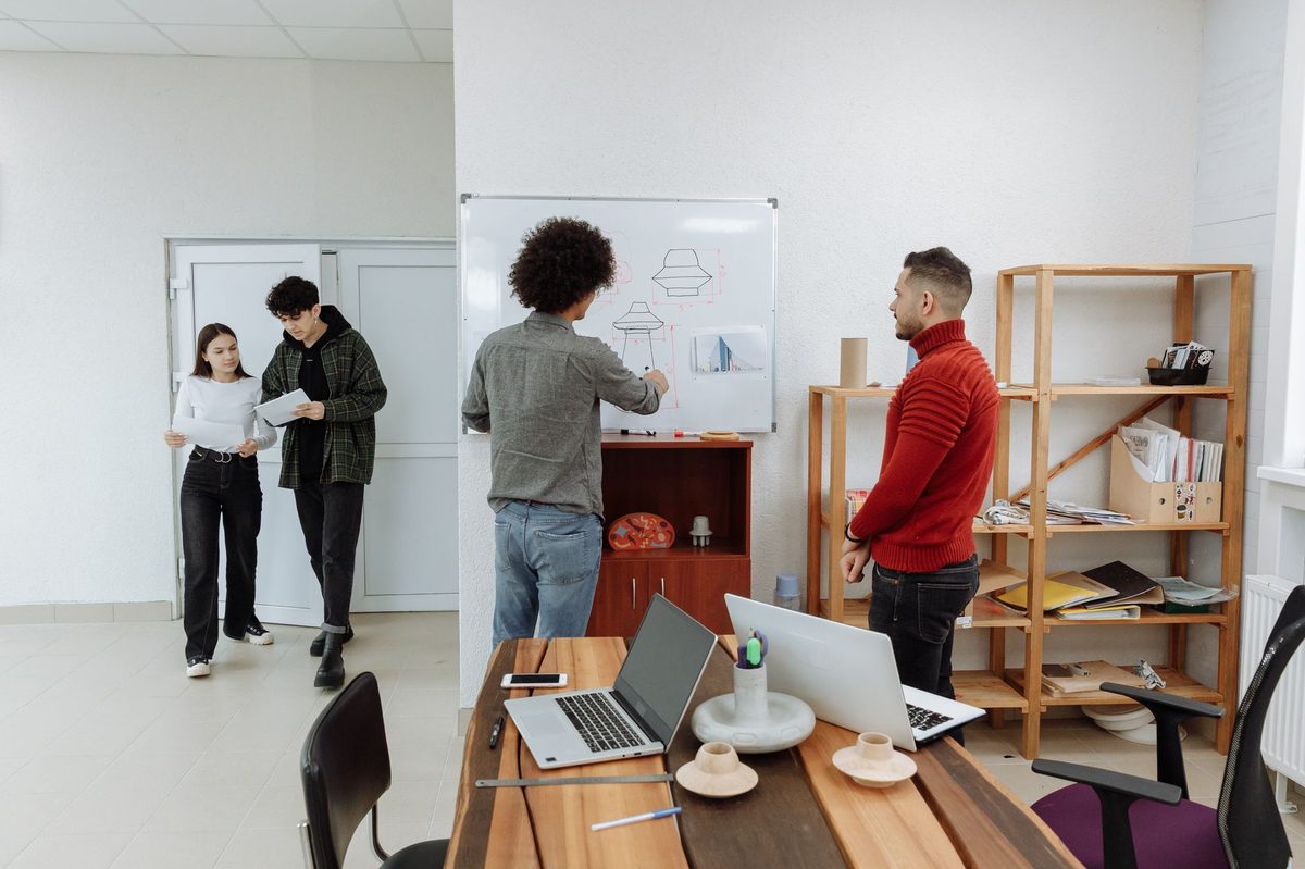 Equipo dibujando el mapa de un proceso en una pizarra de la oficina