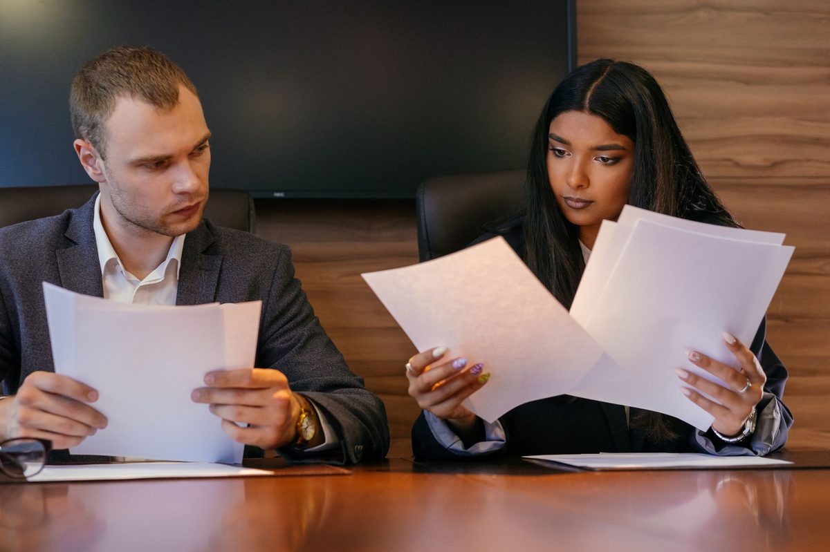Dos personas de una empresa revisando en papel los pasos de un proceso antes de automatizarlo