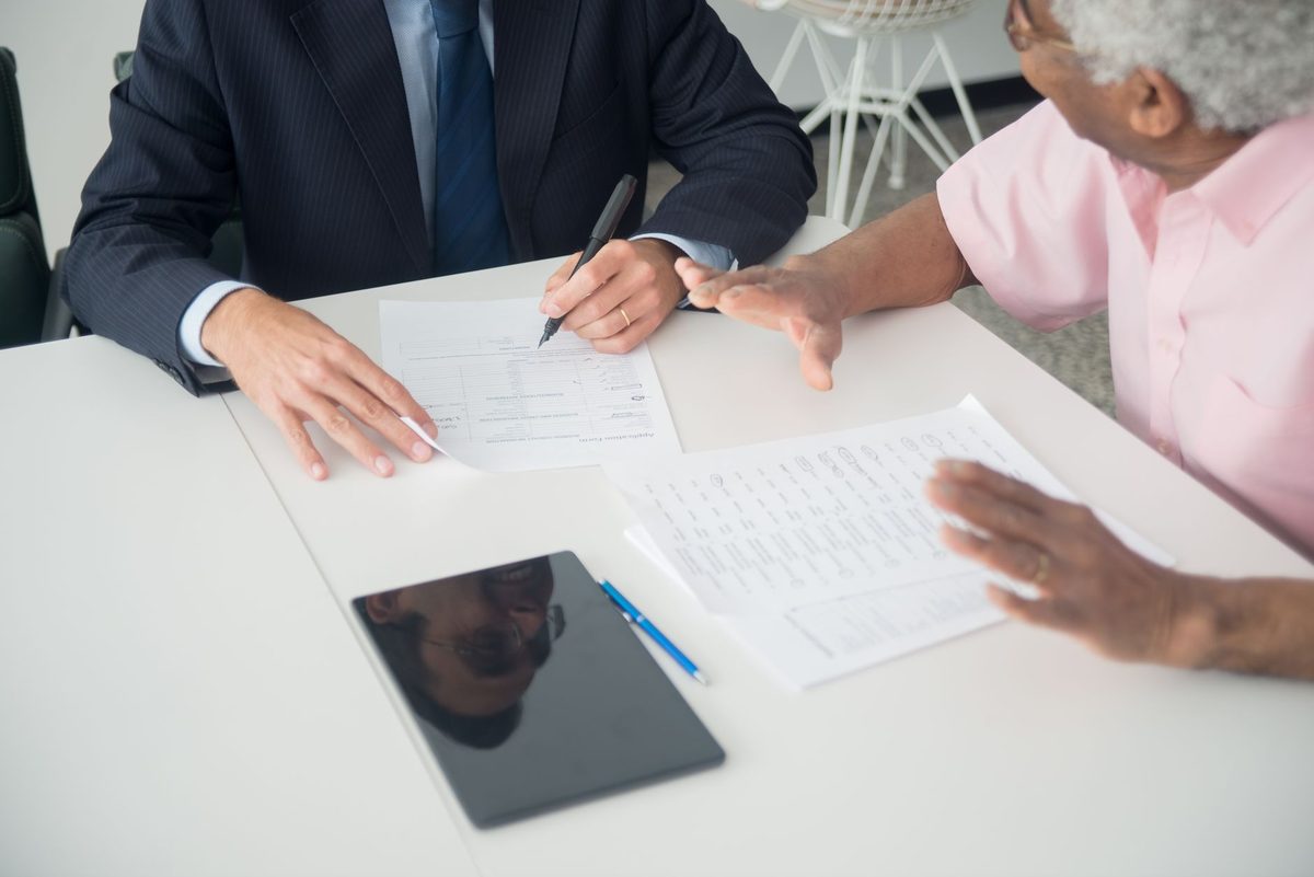 Consultor revisando documentos y contratos sobre el escritorio de un despacho profesional