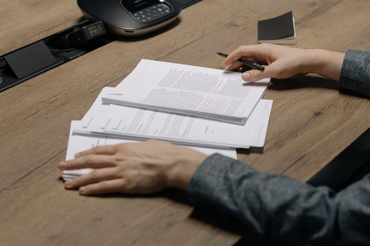 Persona revisando documentos en el escritorio para detectar errores en un proceso automatizado