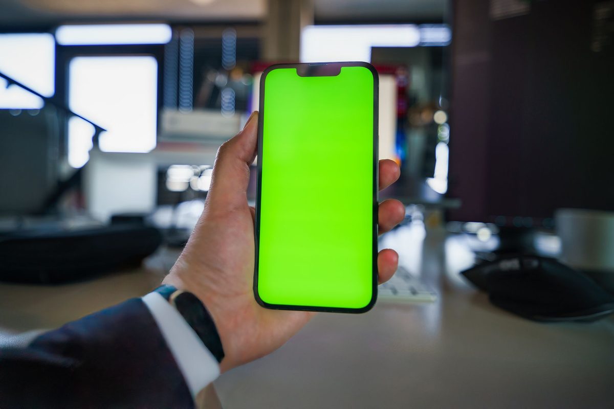 Equipo de oficina consultando el movil con una aplicacion de chat abierta